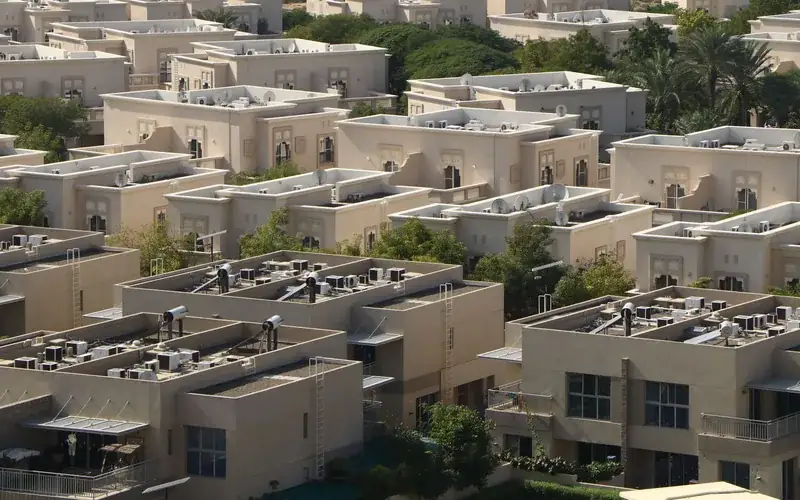 Edificios residenciales de poca altura entre árboles y palmeras en una comunidad de Dubái